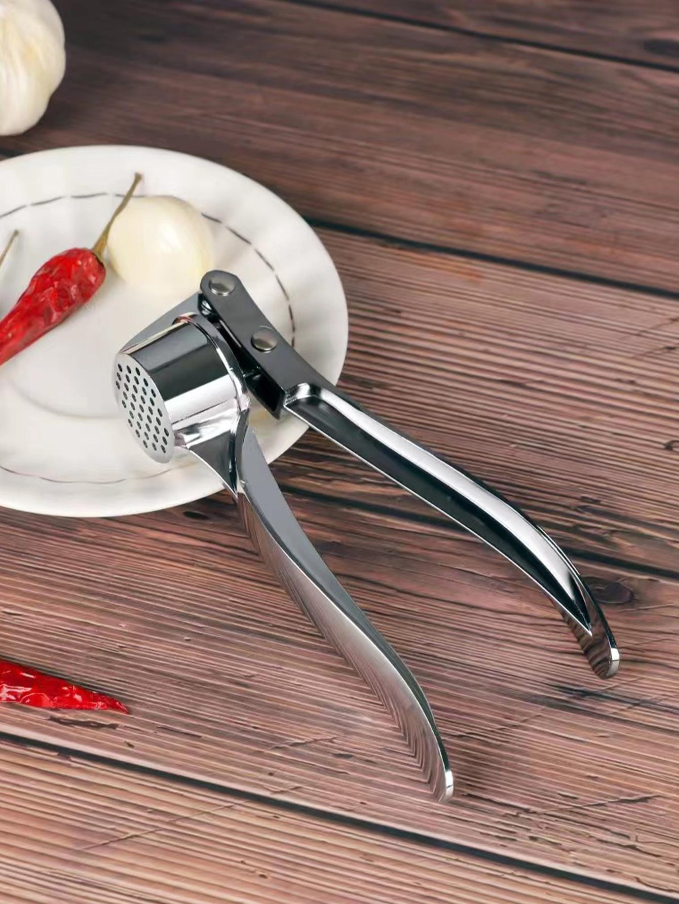 One stainless steel garlic press, a modernist silver multifunctional garlic mincer for the kitchen.